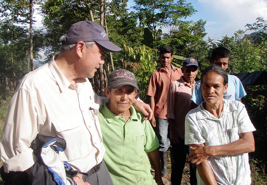 ELM partner Skip Li, left, visits with a couple who live in the village that ELM sponsors, Agroaldea San José.