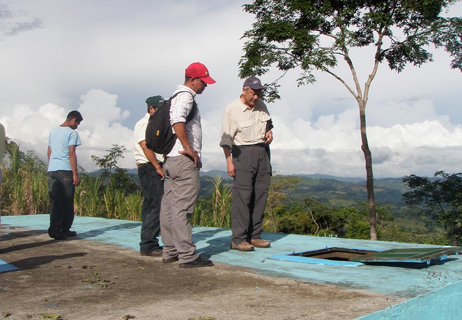 ELM partner Skip Li, right, looks at an irrigation tank in Agroaldea San José. ELM’s sponsorship enabled Agros to install a new pump that carries water to the tank.